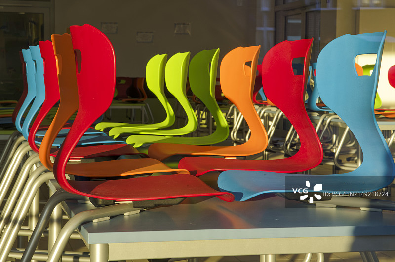 教室里堆放在桌子上的一排排彩色椅子图片素材
