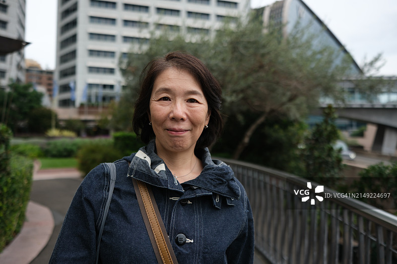 城市花园里的微笑女人肖像图片素材