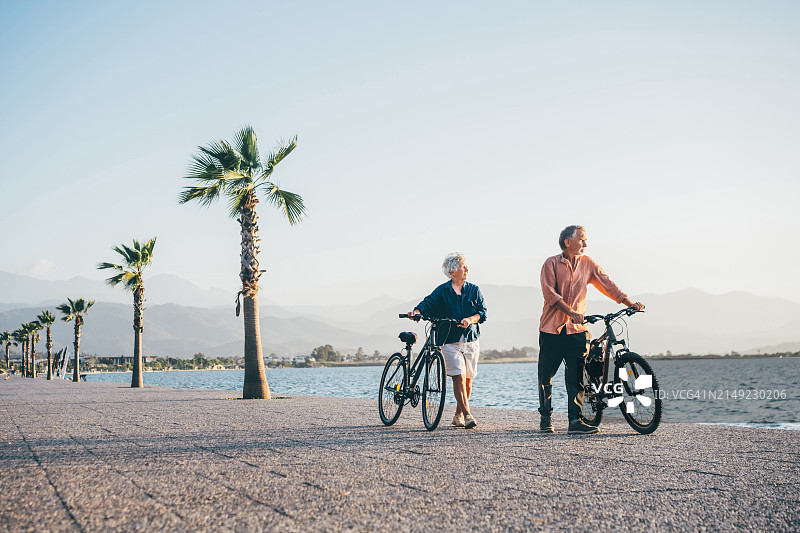 中年夫妇在海边木板路上骑自行车图片素材