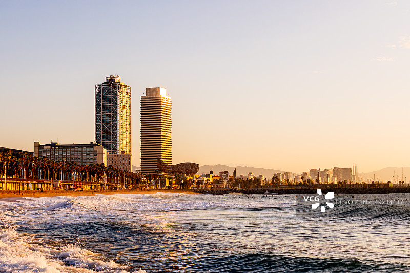 加泰罗尼亚巴塞罗那：阳光明媚的早晨，巴塞罗内塔海滩和城市天际线图片素材