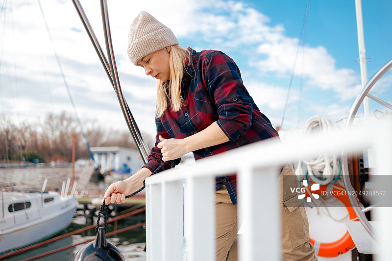 女水手将船挡泥板系在船上图片素材