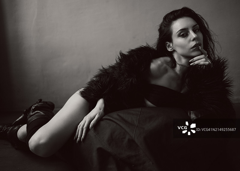 年轻女子看着相机，手指放在嘴唇上图片素材