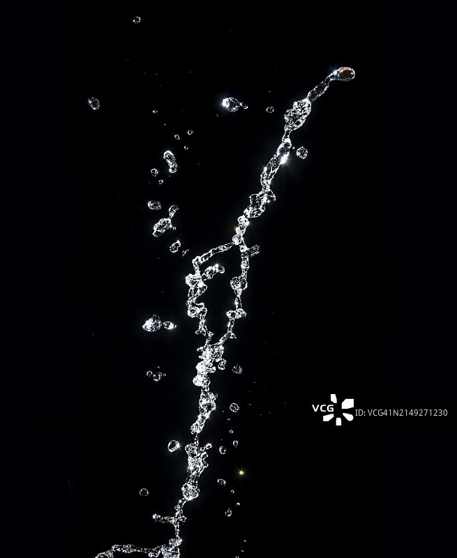 黑色背景上向上溅起的水滴和水花图片素材