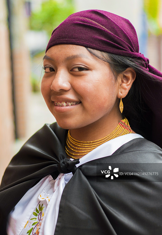 一位戴着紫色围巾和黑色披肩的厄瓜多尔女性，神秘优雅地看着镜头图片素材