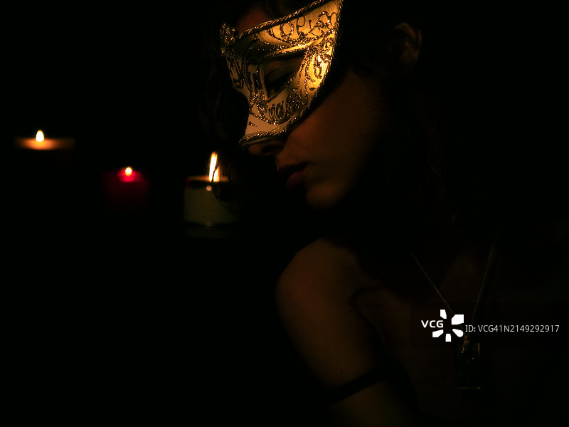 戴威尼斯面具和拿着蜡烛的女人图片素材