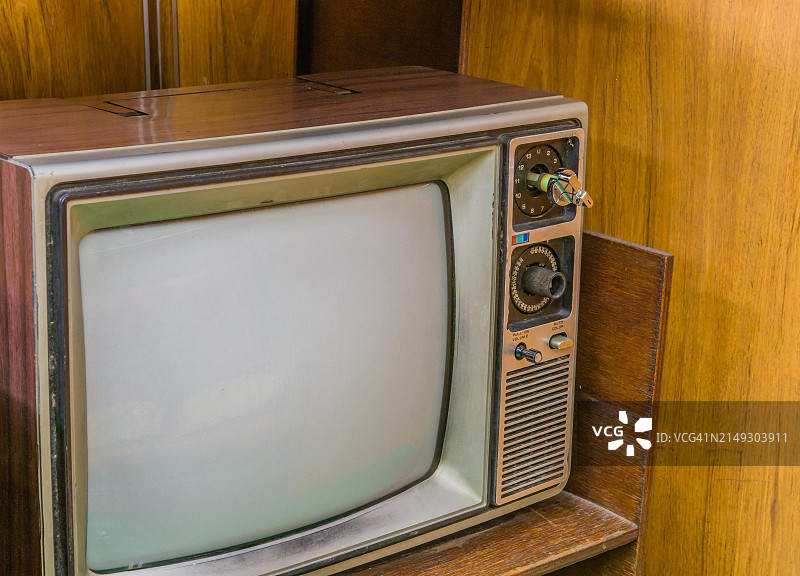 放置在木桌上的19英寸老式木纹电视机。位于韩国江陵公共公园展出的旧海军舰艇上图片素材
