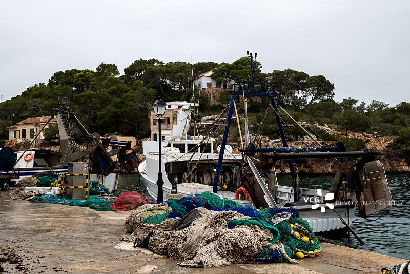 西班牙马略卡岛卡拉菲格拉渔港的渔船和渔网图片素材
