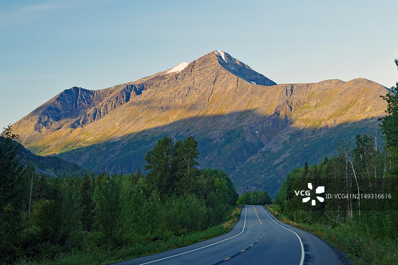 阿拉斯加理查森公路的清晨阳光照耀下的山路图片素材