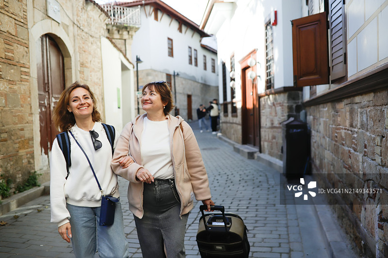 家庭旅行：中年母女探索老城街道图片素材