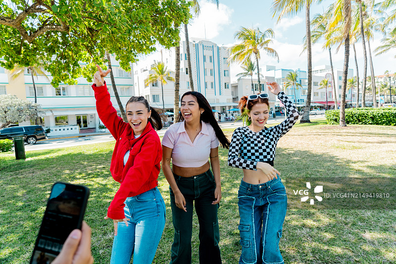 年轻的朋友们在公园录制跳舞视频图片素材