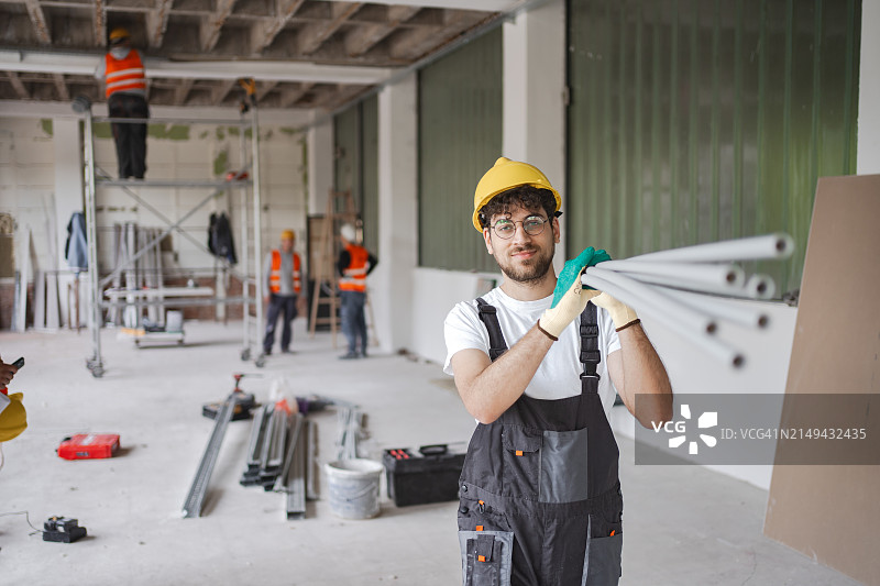 肩扛管道的男性建筑工人图片素材