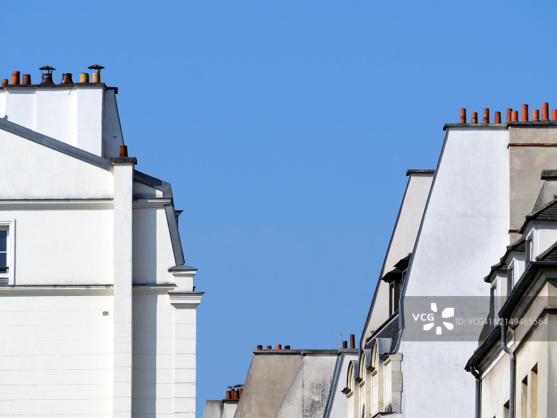 巴黎玛莱区几栋住宅楼的白色山墙和外墙特写，阳光明媚，蓝天白云图片素材