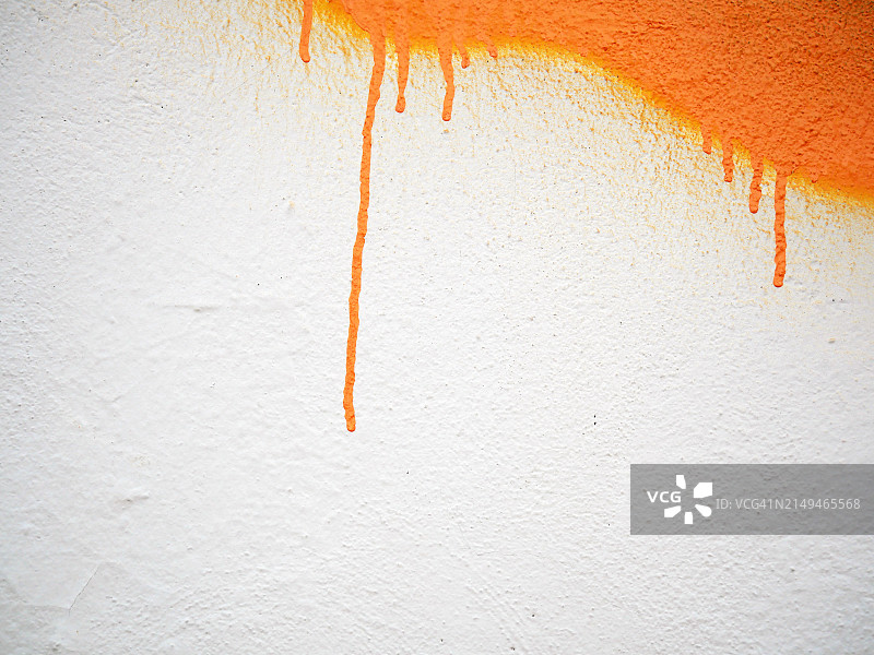 白色纹理墙壁上滴落的橙色油漆，阳光明媚，自然色彩，法国巴黎图片素材