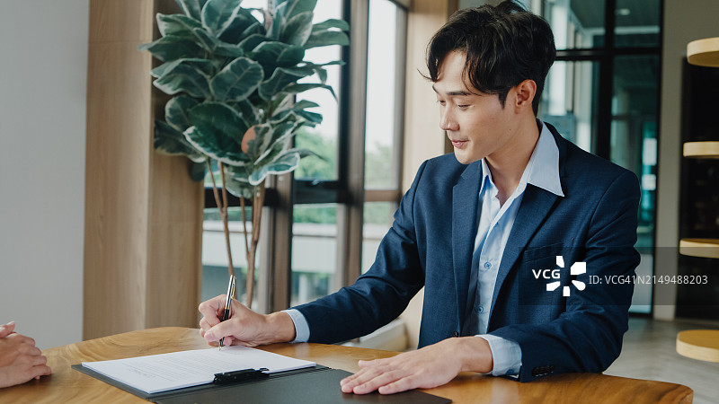 年轻亚洲男商人办公室签署投资协议握手图片素材