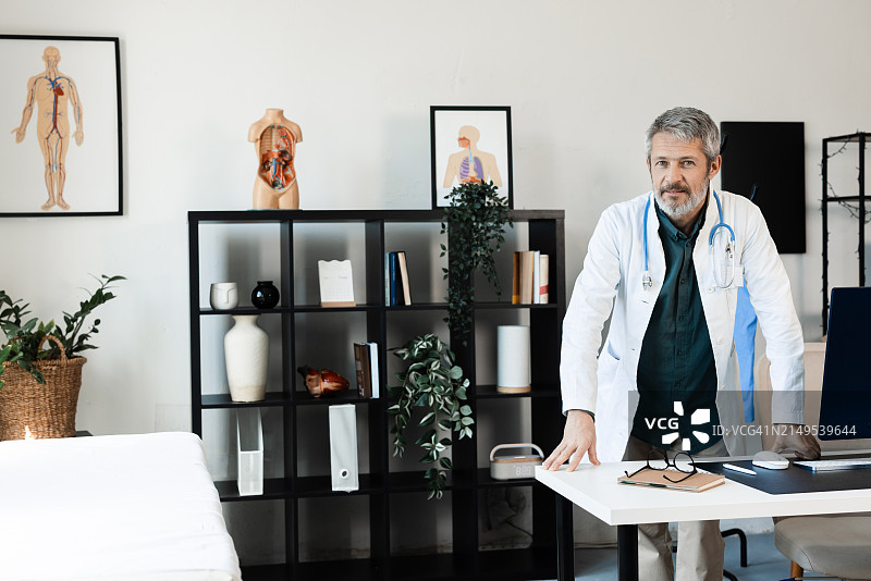 在他的办公室里的一位中年医生肖像图片素材