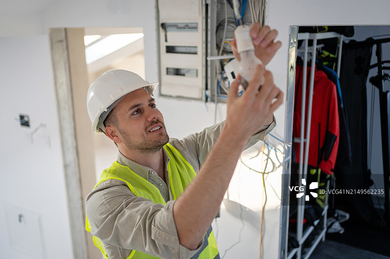 电工使用工具安全连接装置并点亮空间图片素材