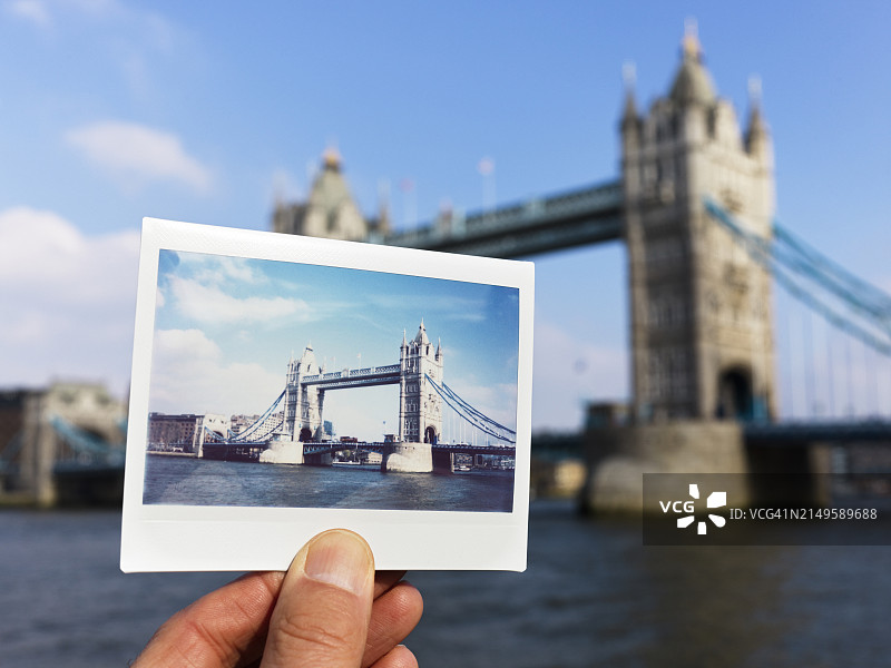 男人在伦敦塔桥前拿着即时胶片照片图片素材