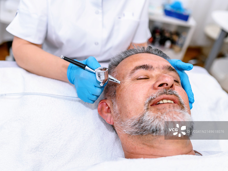 在水疗中心接受喷气焕肤的男人图片素材