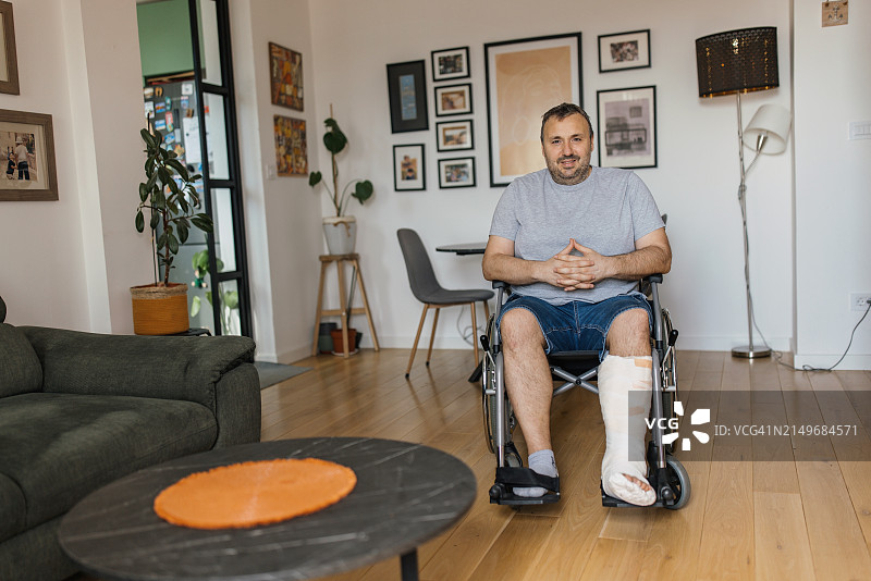 在家庭环境中自信微笑的轮椅男子图片素材
