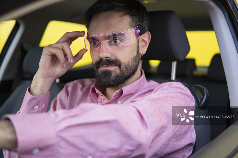 戴智能眼镜坐在车里的男人图片素材
