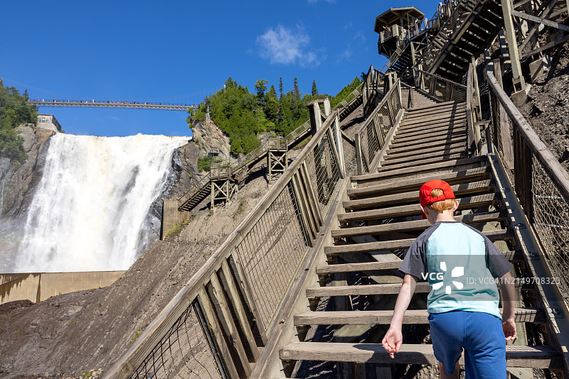 夏季在加拿大魁北克市蒙莫朗西瀑布爬楼梯的男孩图片素材