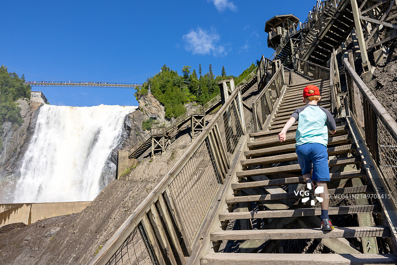 夏季在加拿大魁北克市蒙莫朗西瀑布爬楼梯的男孩图片素材