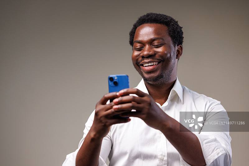 年轻男子使用手机的影棚照片图片素材