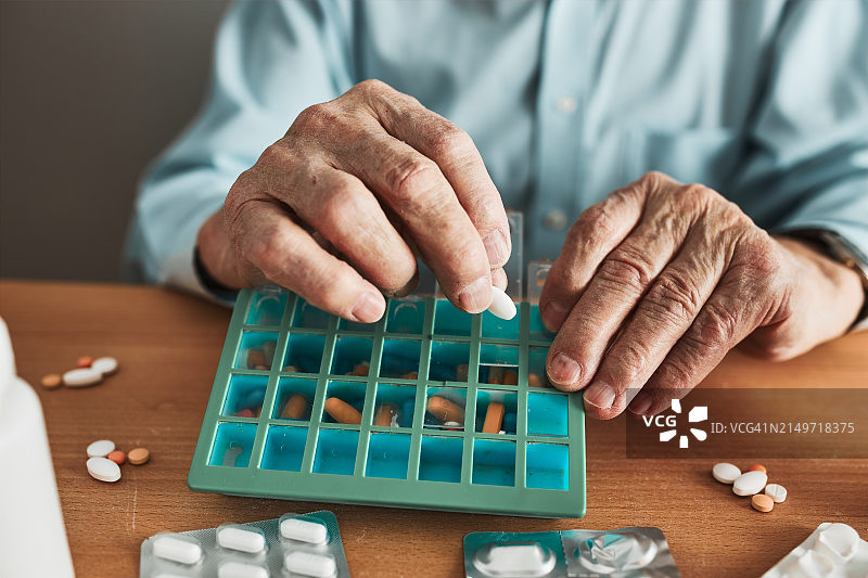 男子手持药丸的腰部特写图片素材