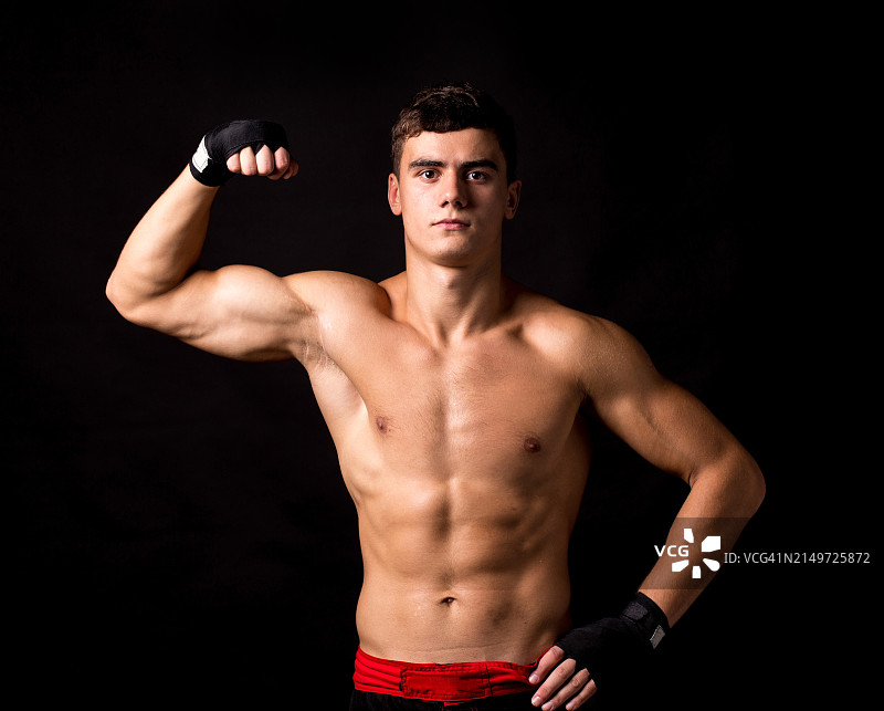 赤膊年轻男子黑色背景肌肉展示肖像图片素材