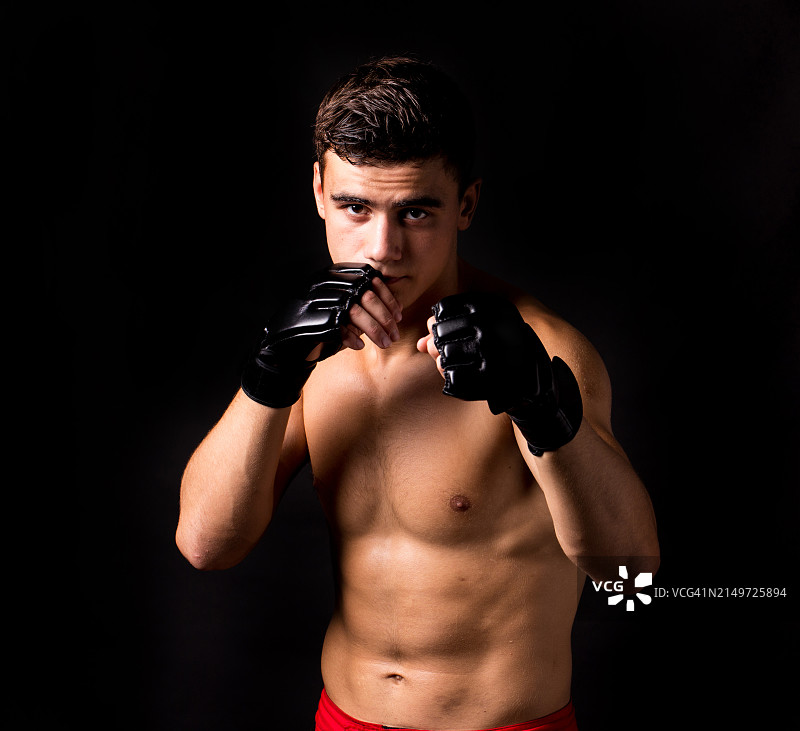 黑色背景前，赤膊拳击手的肖像图片素材