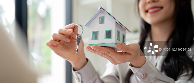 女商人拿着房屋模型在办公室图片素材