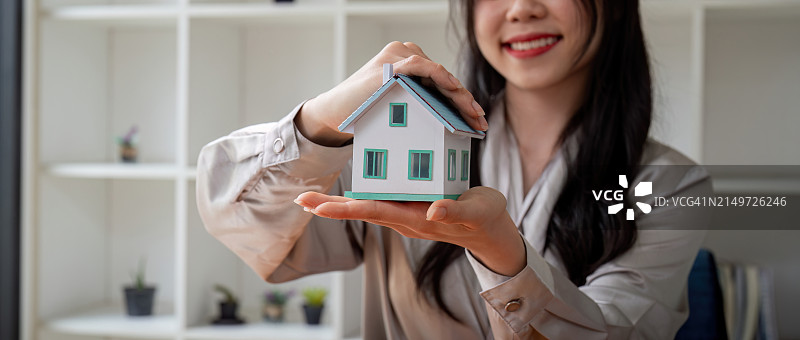 女子手持房屋模型的中段图片素材
