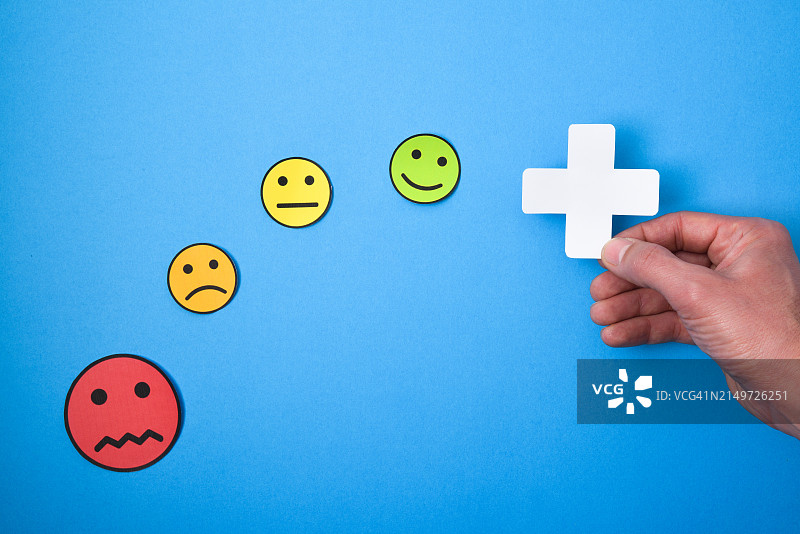 裁剪的手拿着拟人化的脸，蓝色背景图片素材