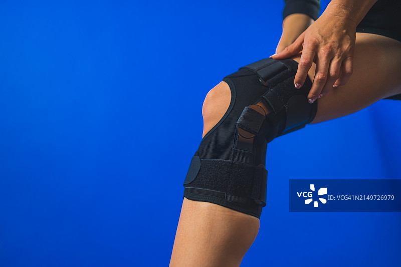 在蓝色背景下锻炼的女人身体中部图片素材