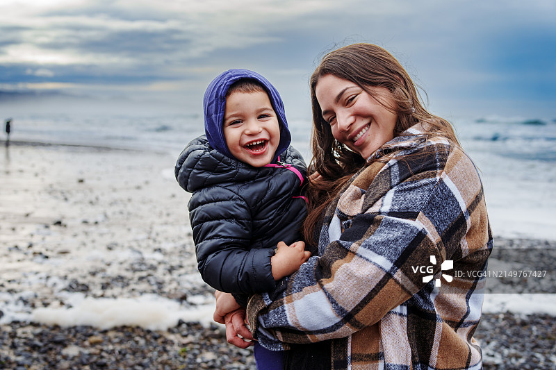 在俄勒冈海岸微笑的女人和幼儿儿子图片素材