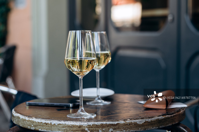 欧洲城市街头酒吧桌上的两杯白葡萄酒图片素材