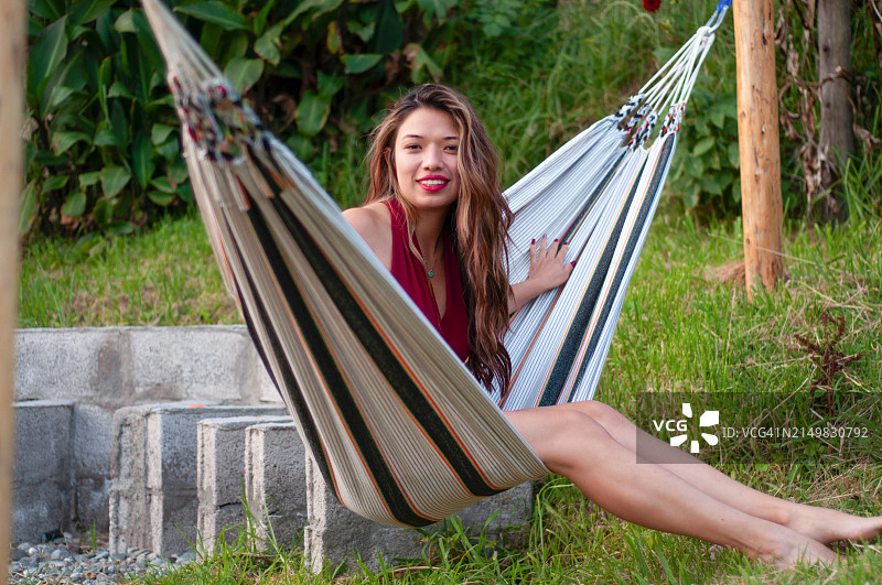 美丽的旅行爱好者在条纹吊床上放松身心，沉浸在厄瓜多尔茂盛环境的宁静氛围中图片素材