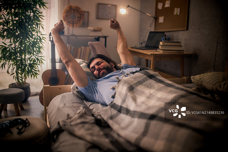 清晨醒来伸懒腰的年轻男人图片素材