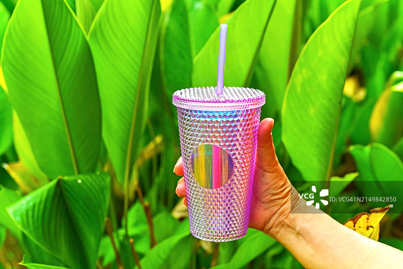 女士手持可重复使用的杯子和吸管图片素材