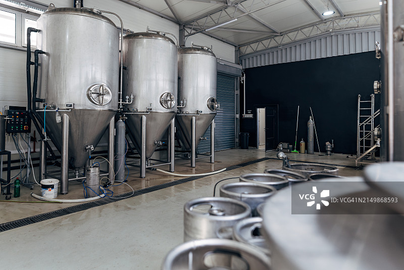 一排闪亮的金属微型啤酒厂罐体图片素材