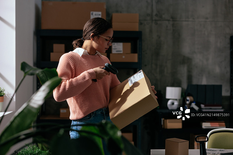 女工扫描并检查包裹图片素材