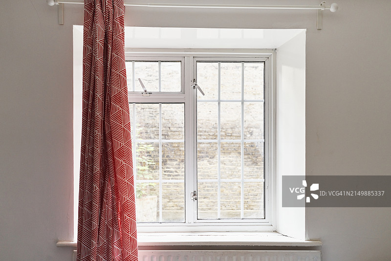 带有红色窗帘的公寓窗户，室外的光线穿过玻璃图片素材
