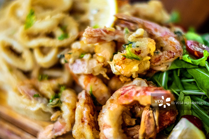 海鲜拼盘，搭配万寿菊、虾尾、樱桃番茄和罗勒沙拉、炸薯条图片素材