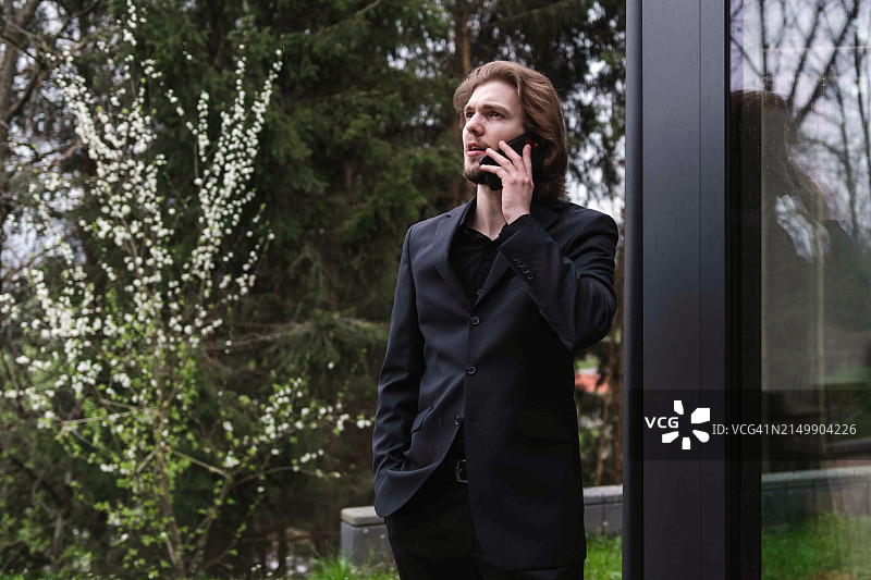 在办公室外打电话的年轻男士图片素材