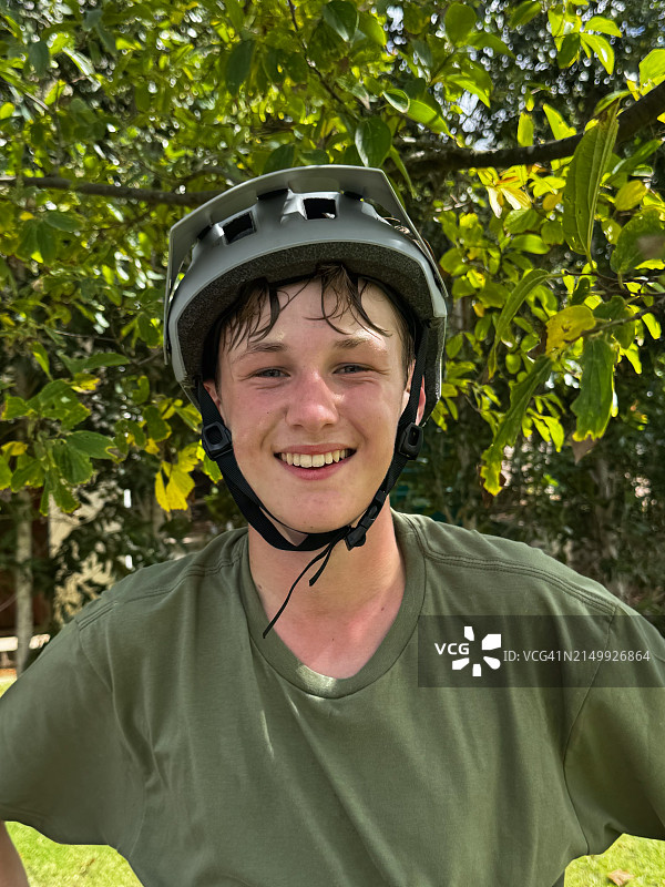 笑容满面的青少年骑行者肖像，头戴自行车头盔图片素材