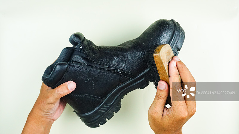 在白色背景上用手刷黑色鞋子图片素材