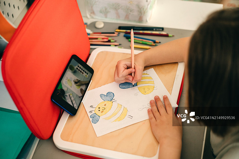 俯视：女孩用铅笔画蜜蜂情侣图片素材