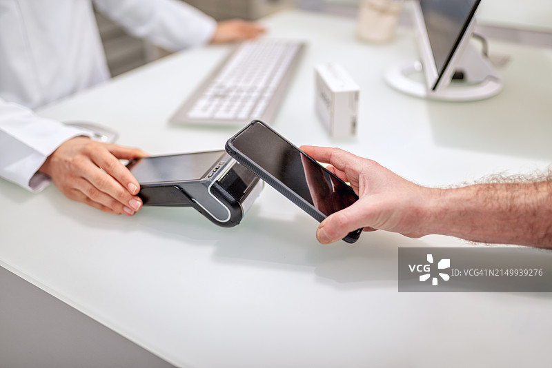 男人在药房结账时支付药品费用图片素材