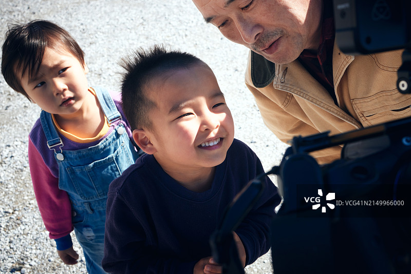 男孩们很高兴看到祖父拍的照片图片素材