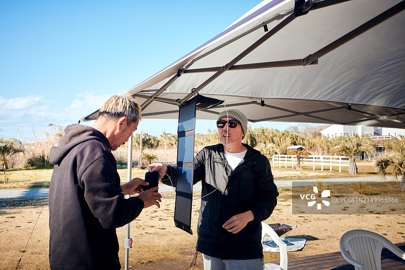 男人们安装用于露营的太阳能电池板图片素材